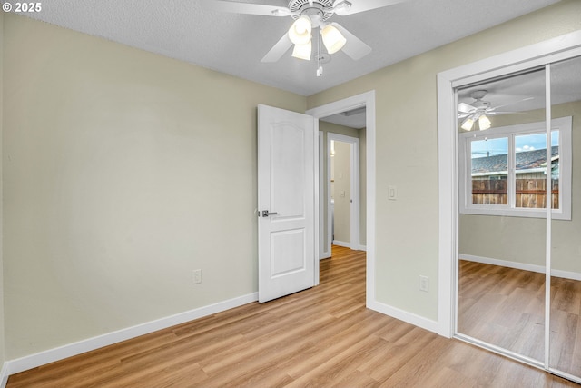 unfurnished bedroom featuring ceiling fan, light hardwood / wood-style floors, and a closet