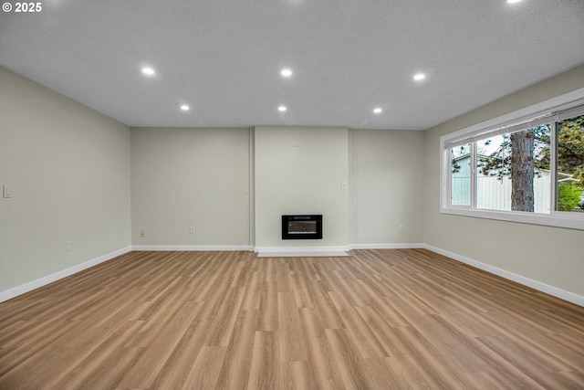 unfurnished living room with heating unit and light wood-type flooring