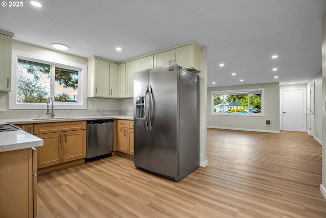 kitchen featuring appliances with stainless steel finishes, sink, and light wood-type flooring