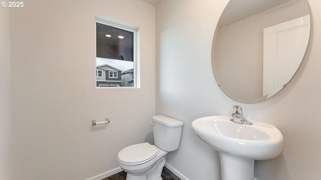 bathroom with wood-type flooring, toilet, and sink