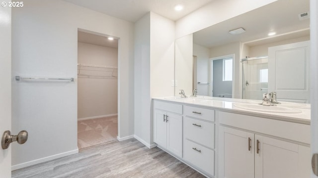 bathroom with vanity, wood-type flooring, and walk in shower