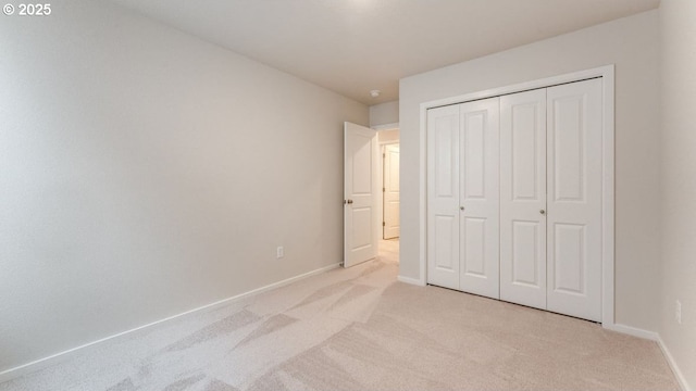 unfurnished bedroom featuring light carpet and a closet