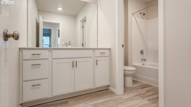 full bathroom featuring vanity, hardwood / wood-style floors, tub / shower combination, and toilet