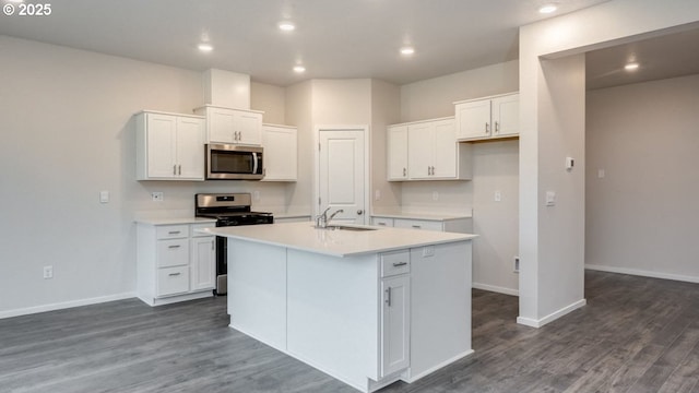 kitchen featuring an island with sink, white cabinetry, sink, dark hardwood / wood-style flooring, and stainless steel appliances