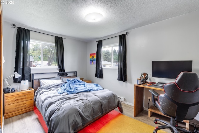 405 Redpath St, Kelso, WA 98626 - bedroom featuring a textured ceiling, wood finished floors, an office area, and baseboard heating