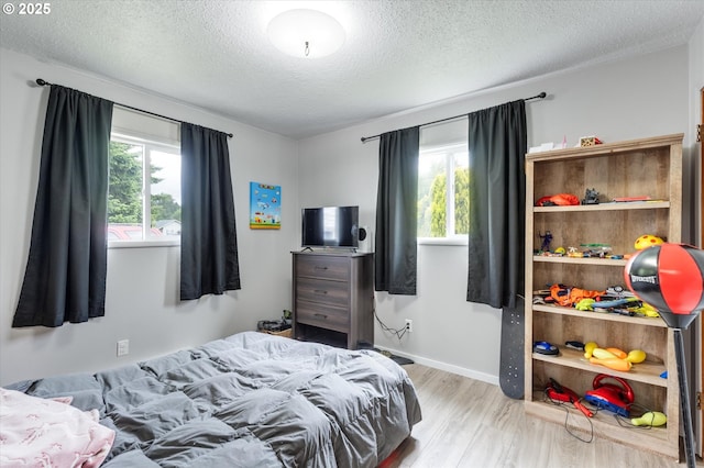 405 Redpath St, Kelso, WA 98626 - bedroom with multiple windows, wood finished floors, a textured ceiling, and baseboards