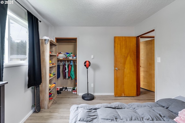 405 Redpath St, Kelso, WA 98626 - bedroom featuring light wood finished floors, a textured ceiling, a closet, baseboards, and a spacious closet