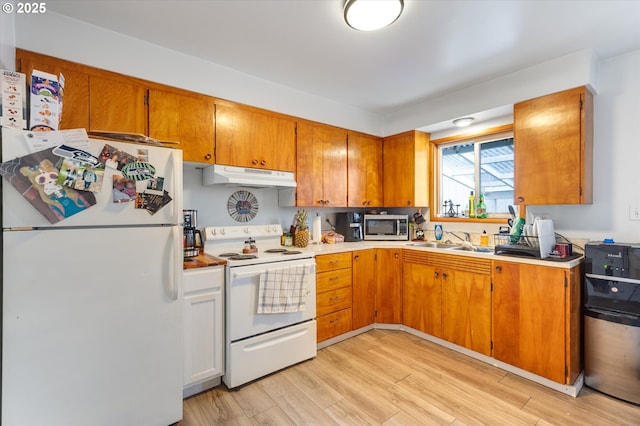 405 Redpath St, Kelso, WA 98626 - kitchen featuring white appliances, under cabinet range hood, light wood-type flooring, light countertops, and brown cabinets