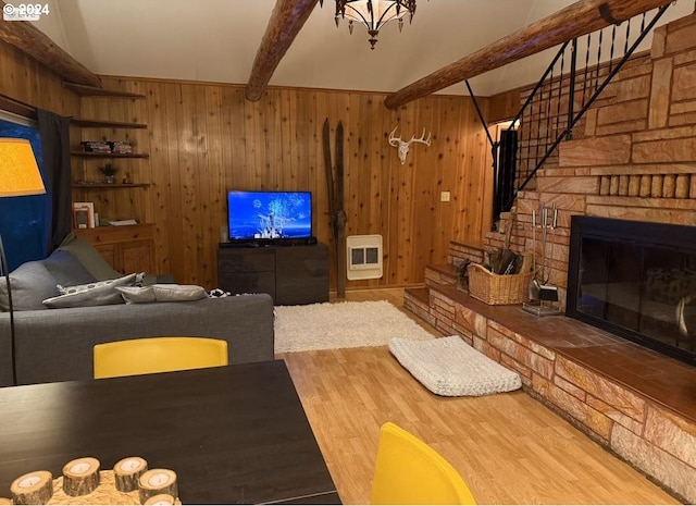 living room with heating unit, hardwood / wood-style flooring, wooden walls, beamed ceiling, and a fireplace