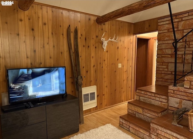 living room featuring beamed ceiling, heating unit, wooden walls, and light hardwood / wood-style flooring