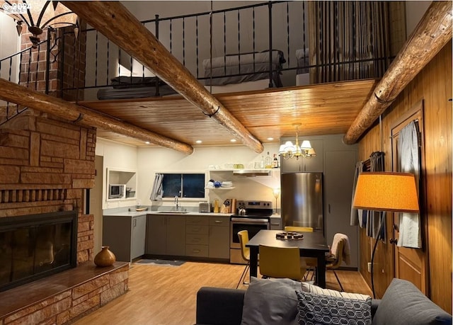 kitchen with beamed ceiling, sink, light hardwood / wood-style floors, wood ceiling, and stainless steel appliances