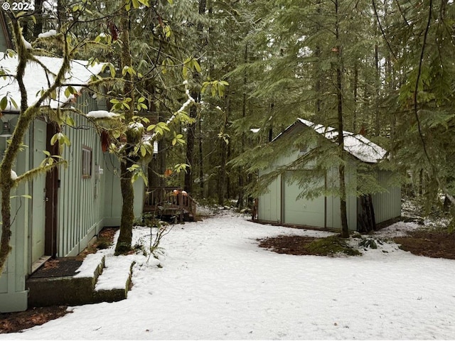 snowy yard featuring an outdoor structure