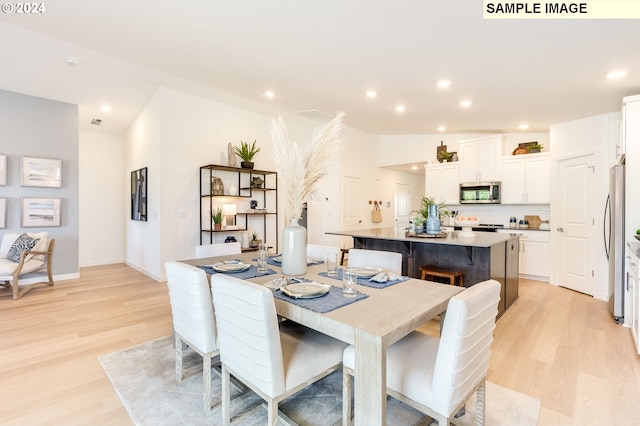 dining area with baseboards, recessed lighting, lofted ceiling, and light wood-style floors
