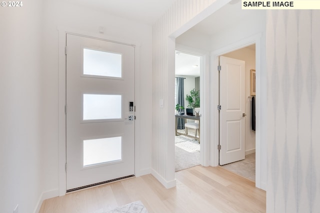 foyer featuring a healthy amount of sunlight, light wood-style floors, and baseboards