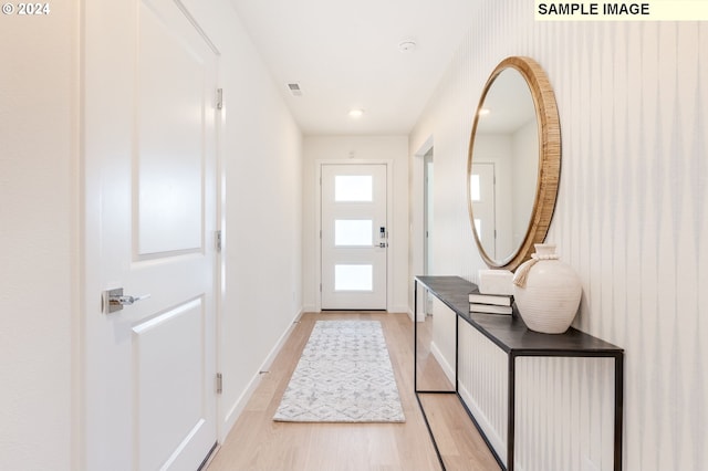 entryway with baseboards, visible vents, and light wood finished floors