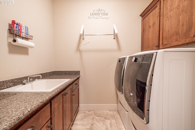 laundry area with cabinets, washing machine and clothes dryer, and sink