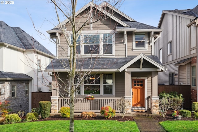 craftsman-style home with roof with shingles and fence