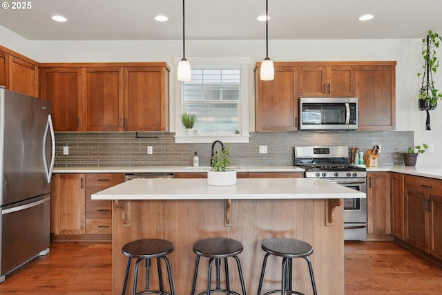 29176 SW Costa Cir E, Wilsonville, OR 97070 - kitchen with stainless steel appliances, a kitchen breakfast bar, light wood-style floors, and recessed lighting