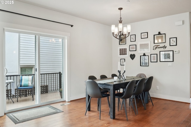 29176 SW Costa Cir E, Wilsonville, OR 97070 - dining room featuring a chandelier, light wood-type flooring, and baseboards