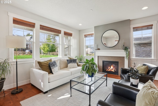 29176 SW Costa Cir E, Wilsonville, OR 97070 - living area featuring wood finished floors, baseboards, a tiled fireplace, and recessed lighting