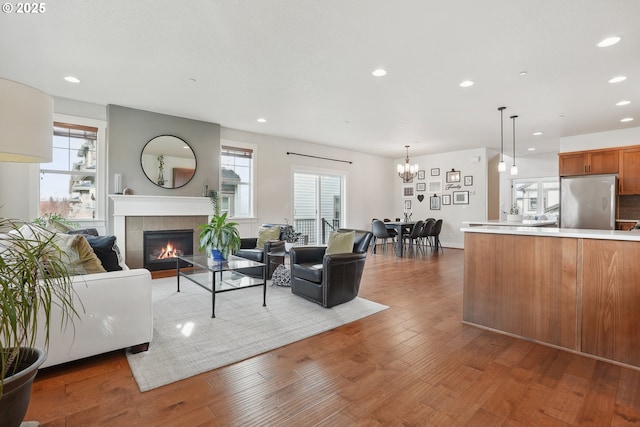29176 SW Costa Cir E, Wilsonville, OR 97070 - living room featuring a tile fireplace, a chandelier, wood finished floors, and recessed lighting