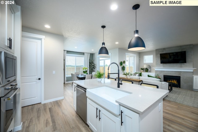 4304 NE 188th St Lot 331, Vancouver, WA 98686 - kitchen with stainless steel appliances, a tiled fireplace, light wood-type flooring, recessed lighting, and light countertops