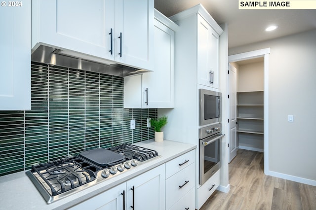 4304 NE 188th St Lot 331, Vancouver, WA 98686 - kitchen featuring appliances with stainless steel finishes, under cabinet range hood, tasteful backsplash, light countertops, and white cabinets