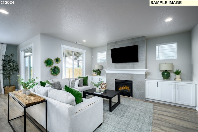 4304 NE 188th St Lot 331, Vancouver, WA 98686 - living area with wood finished floors, a tile fireplace, a textured ceiling, and recessed lighting