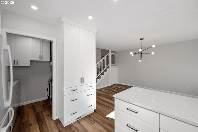 kitchen featuring freestanding refrigerator, wood finished floors, recessed lighting, and light stone countertops