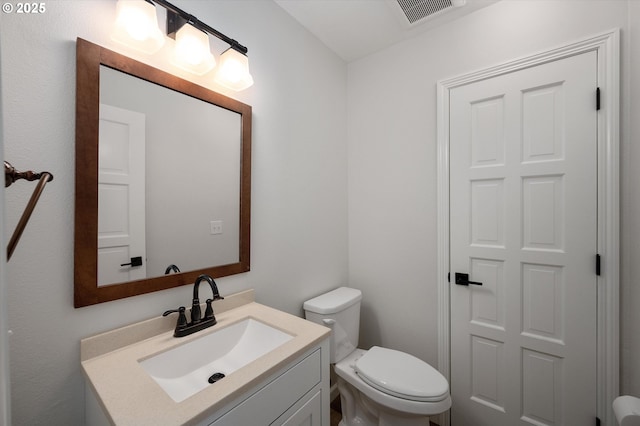 bathroom featuring toilet, visible vents, and vanity