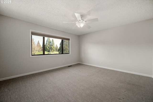 empty room with carpet, visible vents, ceiling fan, and baseboards