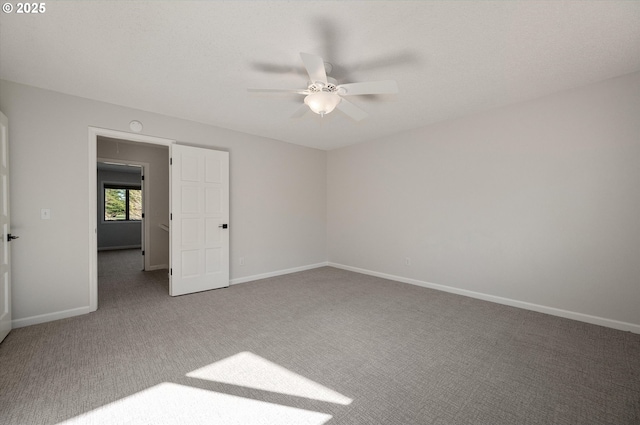 empty room featuring ceiling fan, carpet flooring, and baseboards