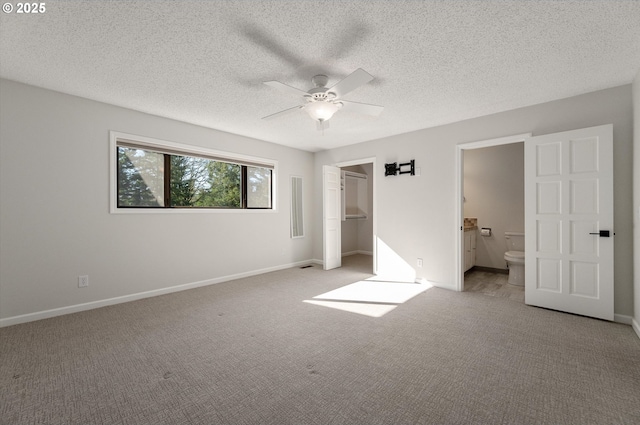 unfurnished bedroom with ensuite bath, baseboards, and light colored carpet