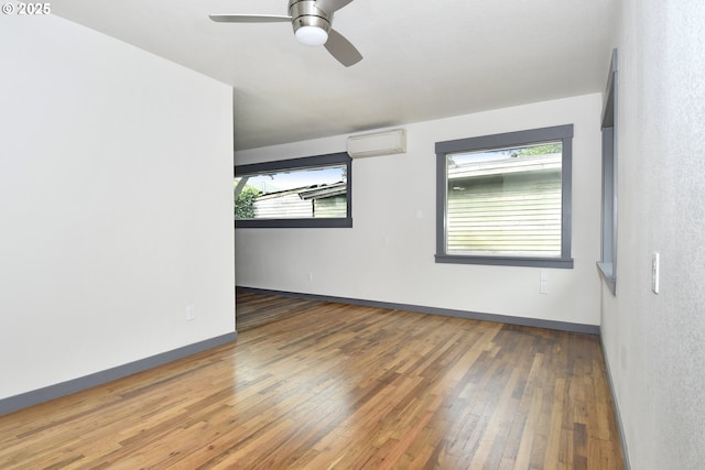 9936 SE Steele St, Portland, OR 97266 - empty room featuring an AC wall unit, hardwood / wood-style floors, and a ceiling fan