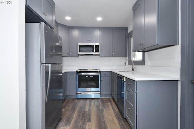 9936 SE Steele St, Portland, OR 97266 - kitchen with stainless steel appliances, gray cabinets, dark wood-style floors, recessed lighting, and light countertops