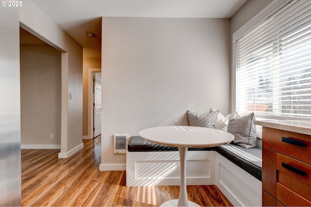 dining area with breakfast area, light wood-type flooring, visible vents, and baseboards