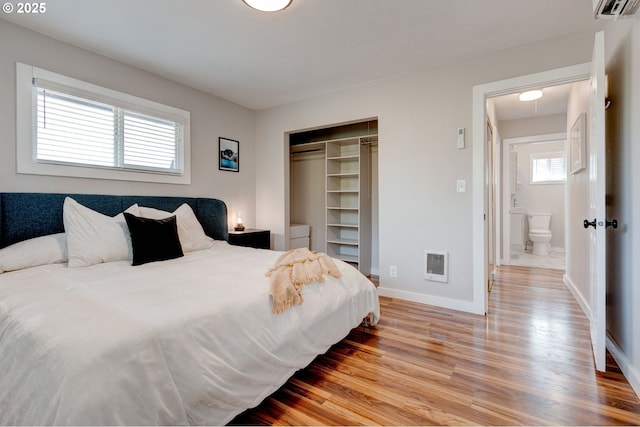 bedroom featuring a closet, wood finished floors, visible vents, and baseboards