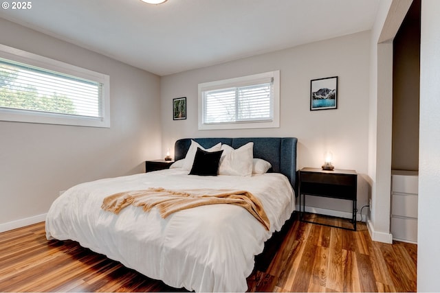 bedroom with baseboards and wood finished floors