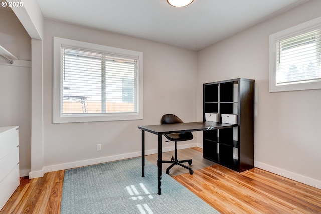 home office featuring plenty of natural light, baseboards, and wood finished floors