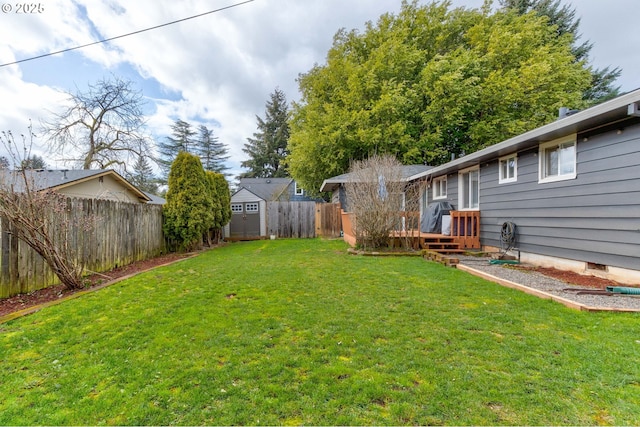 view of yard with a fenced backyard, a shed, a wooden deck, and an outdoor structure