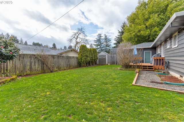 view of yard featuring a shed, an outdoor structure, a fenced backyard, and a wooden deck