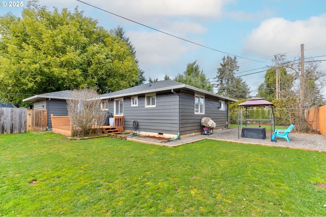 rear view of property featuring crawl space, fence private yard, a wooden deck, and a yard