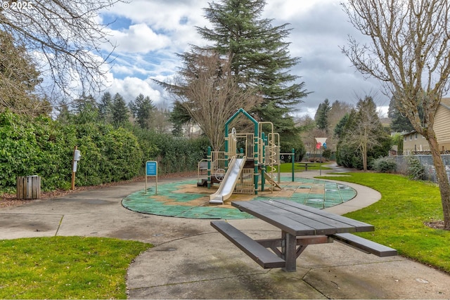 community play area featuring a lawn and fence