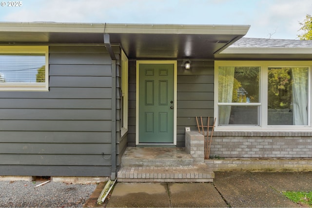 view of exterior entry featuring brick siding