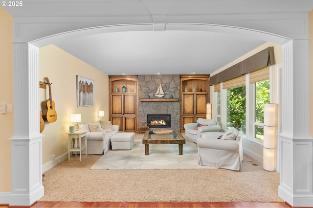 17677 Westview Dr, Lake Oswego, OR 97034 - living room with ornate columns, wood finished floors, a stone fireplace, baseboards, and arched walkways