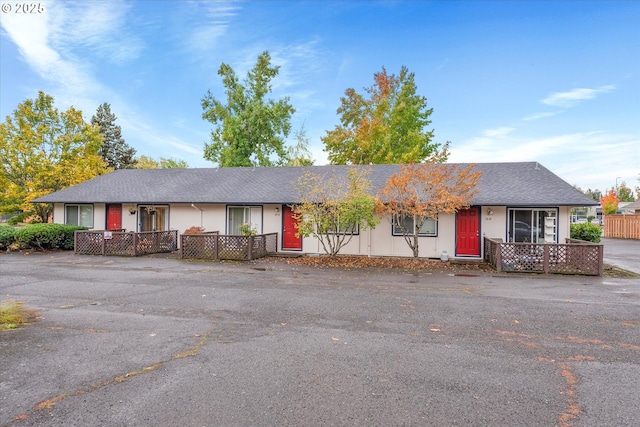 ranch-style house with fence and roof with shingles