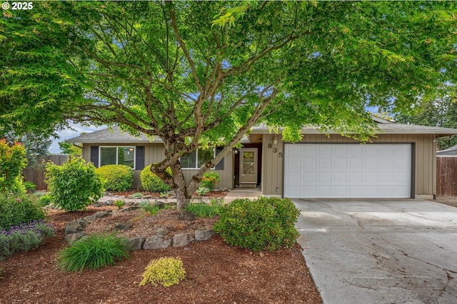 obstructed view of property featuring fence, driveway, and an attached garage