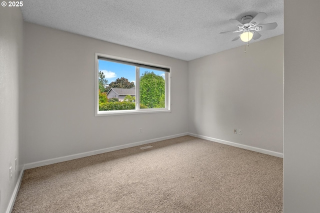 carpeted spare room featuring a textured ceiling, a ceiling fan, and baseboards