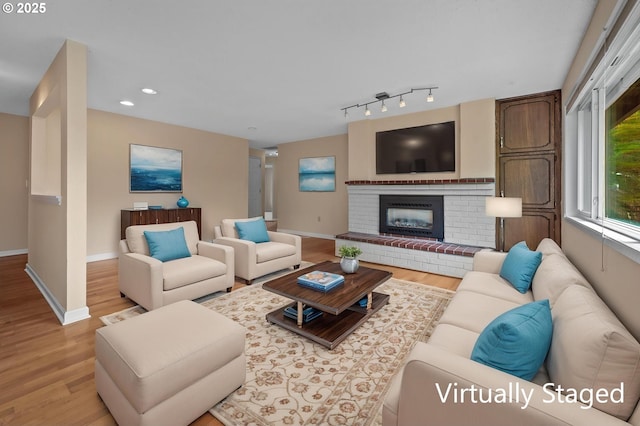living area with wood finished floors, a fireplace, baseboards, and recessed lighting