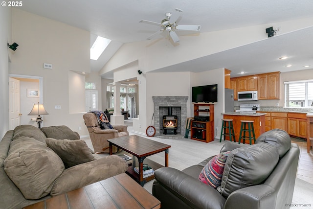 24788 E Mckenzie Valley Ct, Welches, OR 97067 - living area featuring visible vents, a wood stove, ceiling fan, a skylight, and high vaulted ceiling